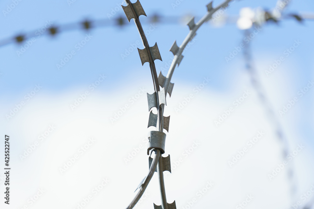 Barbed wire against a blue sky protecting an industrial plant. Barbed wire against a blue sky protecting an industrial plant.