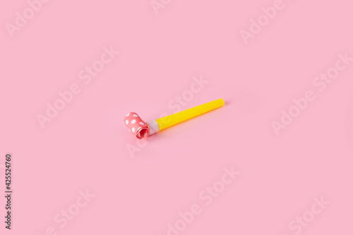 Canvastavla Rolled festive noisemaker or party whistle horn over pink background