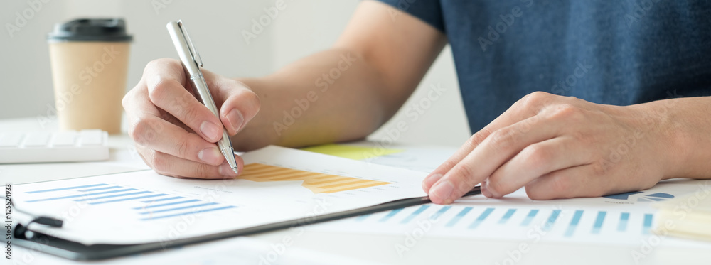 work from home, The hand of a man who works in finance sits at his desk at home and calculates financial graphs showing the results of his investments, planning the steps of his business growth