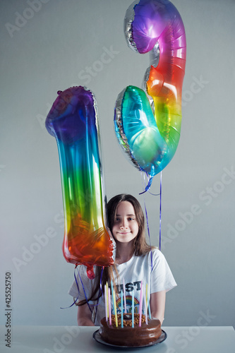 Cute teenager with happy birthday baloons