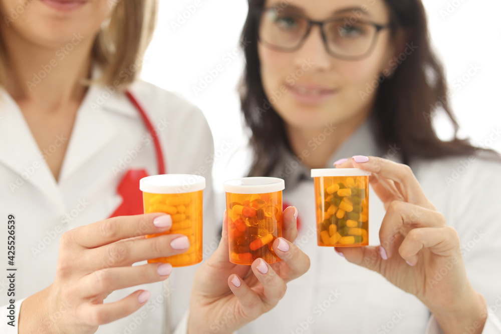 Woman doctor holding jars of medicines closeup Woman doctor holding jars of medicines closeup