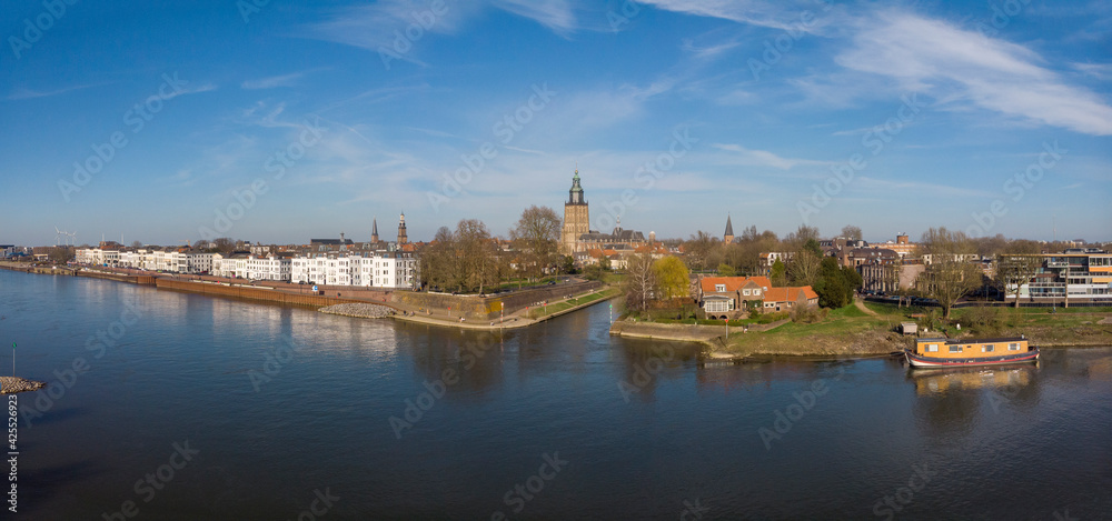 Aerial view of medieval Hanseatic city Zutphen, The Netherlands, with entrance to small Vispoorthaven or Gelre port connected to the river IJssel against a bright blue sky with clouds