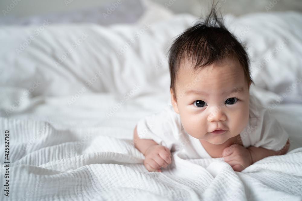 happy asian baby infant learning to crawl on white soft bed. 3 months old baby facial expression. lovely and smile baby. cute kid looking at camera. happy asian baby infant learning to crawl on white soft bed. 3 months old baby facial expression. lovely and smile baby. cute kid looking at camera.