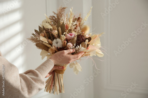 Woman holding beautiful dried flower bouquet at home, closeup © New Africa
