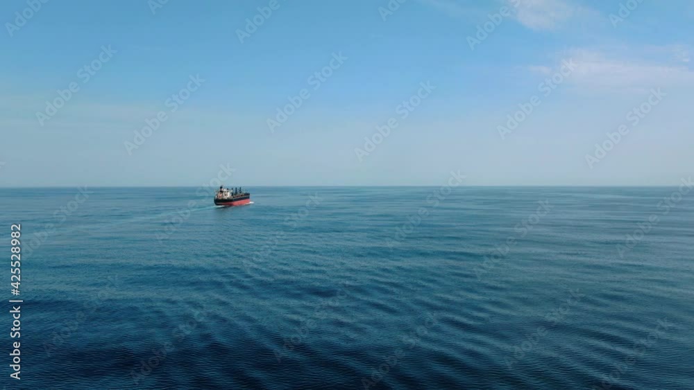 Large cargo ship. A bulk carrier carries cargo across the ocean. Transportation. Delivery. Logistics. A large ship for transporting. Aerial 4k shot. Large cargo ship. A bulk carrier carries cargo across the ocean. Transportation. Delivery. Logistics. A large ship for transporting. Aerial 4k shot.