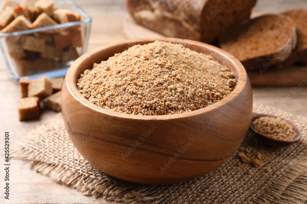 Fresh breadcrumbs in bowl on wooden table Fresh breadcrumbs in bowl on wooden table