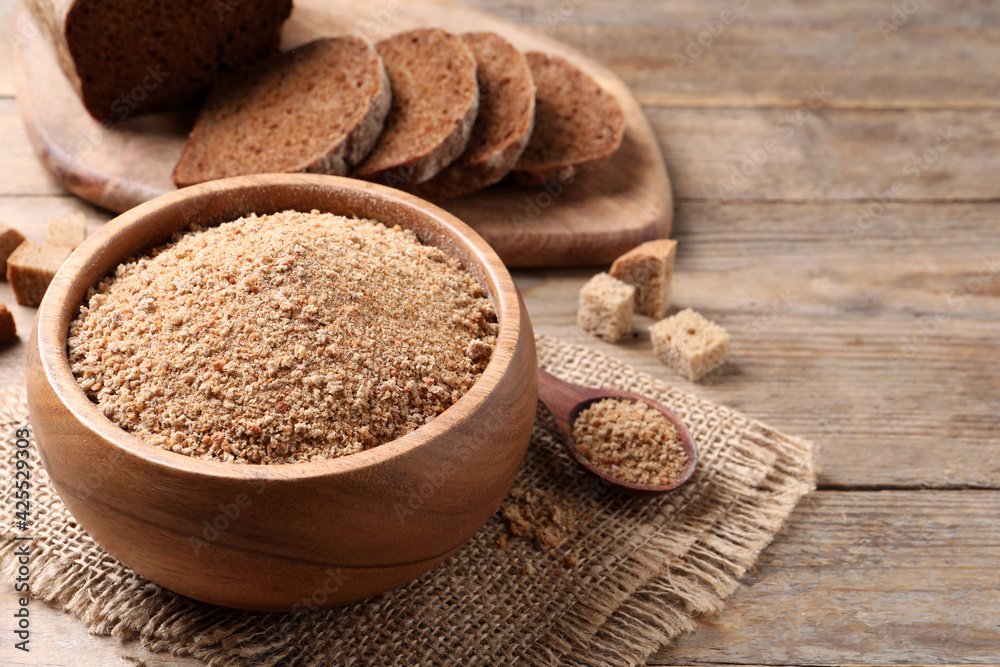Fresh breadcrumbs in bowl on wooden table. Space for text Fresh breadcrumbs in bowl on wooden table. Space for text