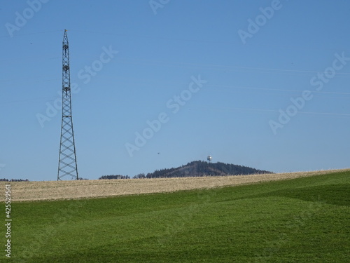 beautiful landscape with powerlines, blue sky and country grass fields