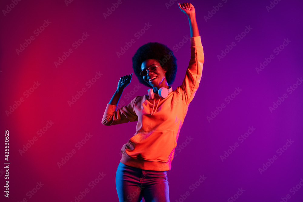 Photo of cheerful girlish clubber lady dance raise arm wear sweatshirt headphones eyewear isolated gradient dark background Photo of cheerful girlish clubber lady dance raise arm wear sweatshirt headphones eyewear isolated gradient dark background