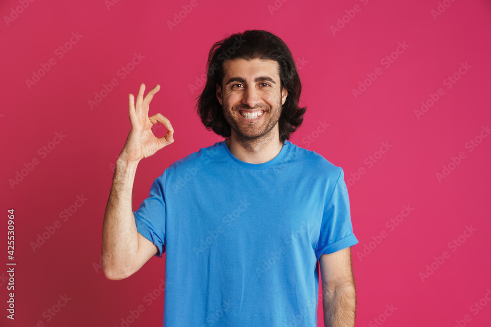 Joyful brunette man in t-shirt smiling and showing ok sign Joyful brunette man in t-shirt smiling and showing ok sign