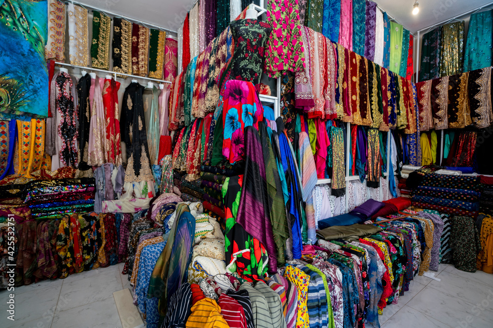Fototapeta premium Rolls of fabric and textiles in a factory shop. Multi different colors and patterns on the market Fabrics in rolls. Fabric store 