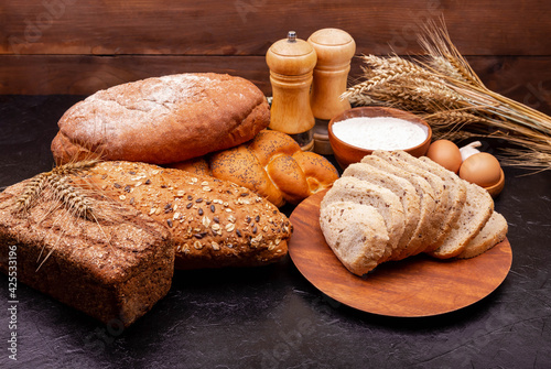 Bread made from wheat and rye flour. Shopping food supermarket concept. Bakery products. Various bread rolls. Healthy bread assortment. Collection of grain bread and baked goods on wooden background.