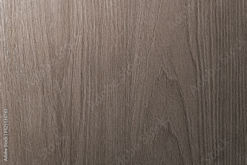 Grey is a brown wooden background with beige veins. Medium dark textured longitudinal cut.