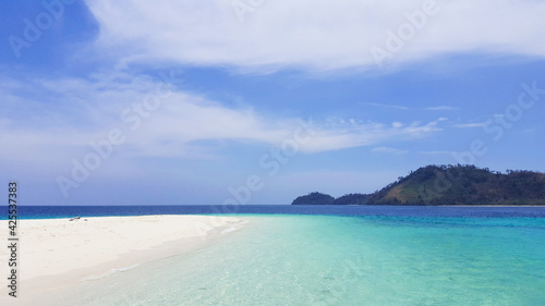 Beautiful white clouds on blue sky over calm sea with sunlight reflection.Sunny sky and calm blue ocean. Vibrant sea with clouds on horizon. © Skies Clear
