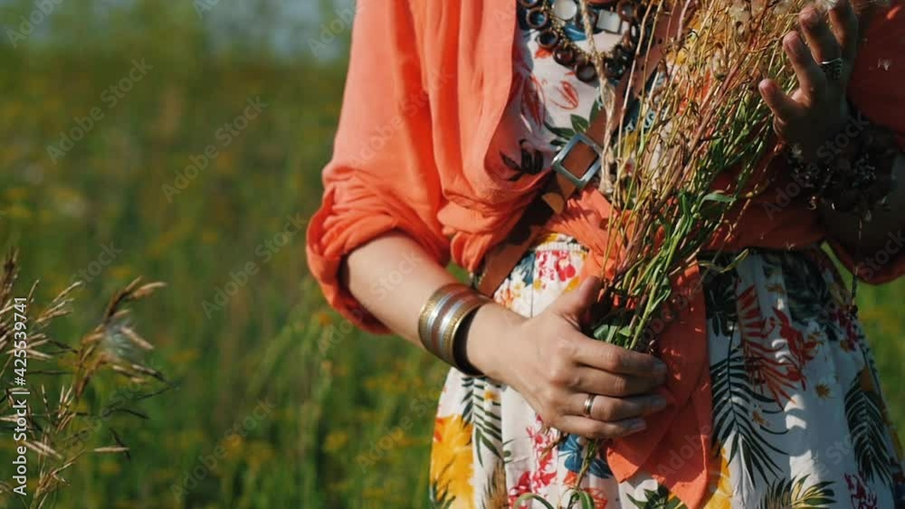 Portrait of blonde hippie dancing in a field with flowers. Woman in boho style on the background of nature. Portrait of blonde hippie dancing in a field with flowers. Woman in boho style on the background of nature.