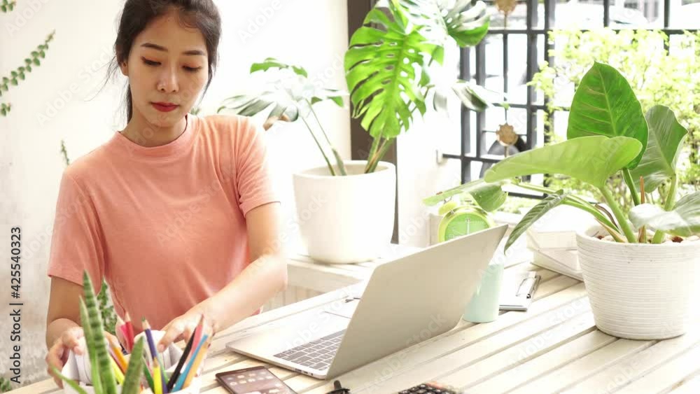 Young people work from home with laptop and listen music in garden nature at home. Asia woman meeting conference connect online with office. Business and Technology Concept Young people work from home with laptop and listen music in garden nature at home. Asia woman meeting conference connect online with office. Business and Technology Concept