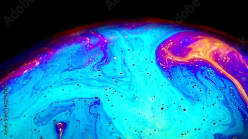 Fluid soap bubble looking like planets. Psychedelic colorful abstract art with urreal patterns of color in motion. photo