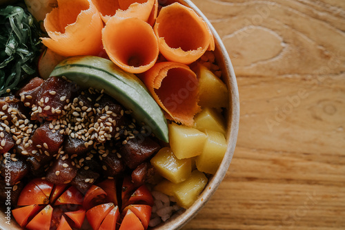 Fotografie Half top view healthy tuna avocado pokebowl on wood table