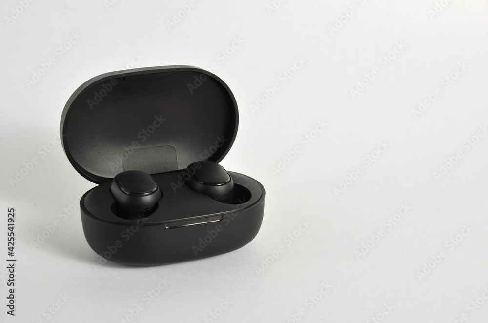 Black wireless headphones in a box on a white background. Black wireless headphones in a box on a white background.