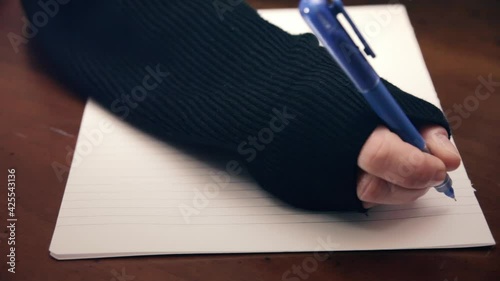 The hand of a woman writing a letter but unable to start. Detail shot.
 photo