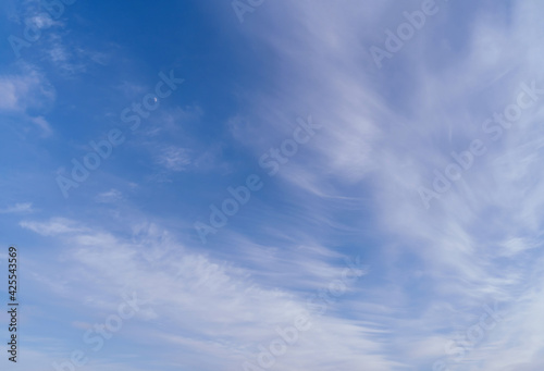 Abstract template with blue sky, white clouds and waxing half moon. Abstract natural background.