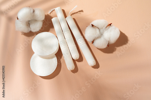 Hygienic tampons and cotton flower on paper background