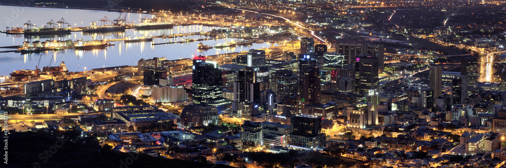 Aerial night panoramic of downtown Cape Town, harbor and Table Bay, South Africa.