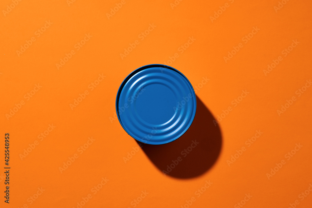 Aesthetic concept with blue painted tin can on orange background Aesthetic concept with blue painted tin can on orange background