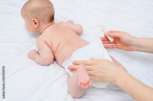 Fotografi close-up - a baby gas passer in the hands of a mother against the background of a baby