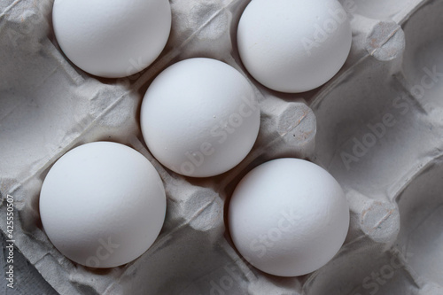 fresh white eggs in eggshells in a box