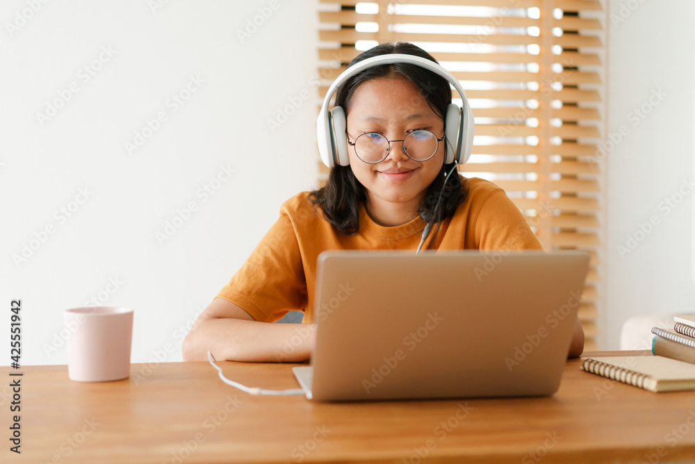 Asian student woman learning online using a computer laptop with headphones Asian student woman learning online using a computer laptop with headphones