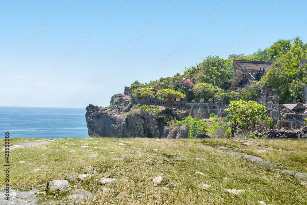 The scenery of green grass and rocks on the cliff
