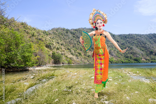 Asian woman dancing Balinese traditional dance (Kembang Girang dance) photo