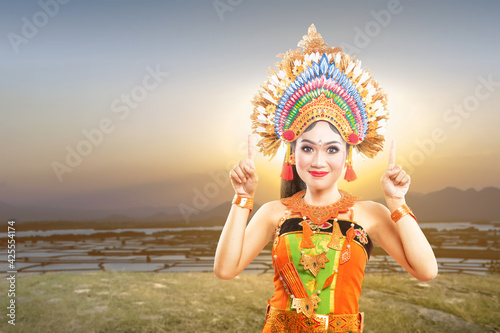 Asian woman with Balinese traditional dance costume pointing something