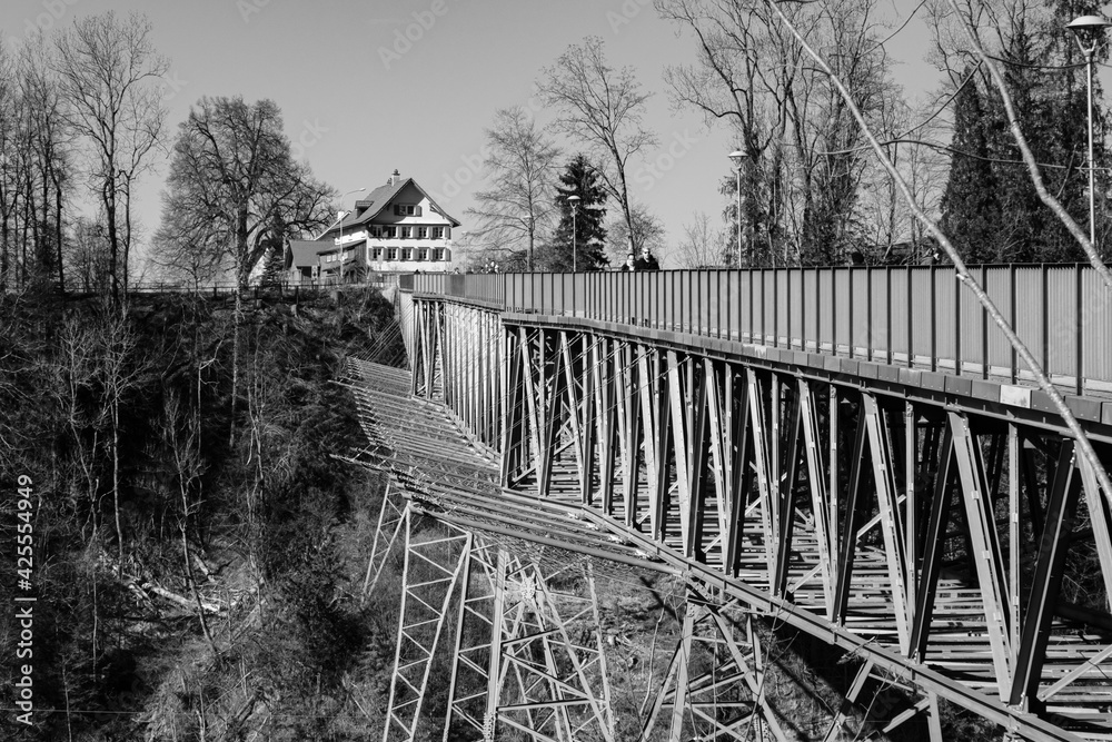 Hohe Stahlbrücke über Starkstromleitung und Fluss