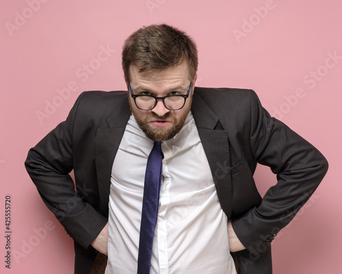 Принти на полотні Caucasian bearded man in glasses and a business suit is embittered and looks furiously into the camera