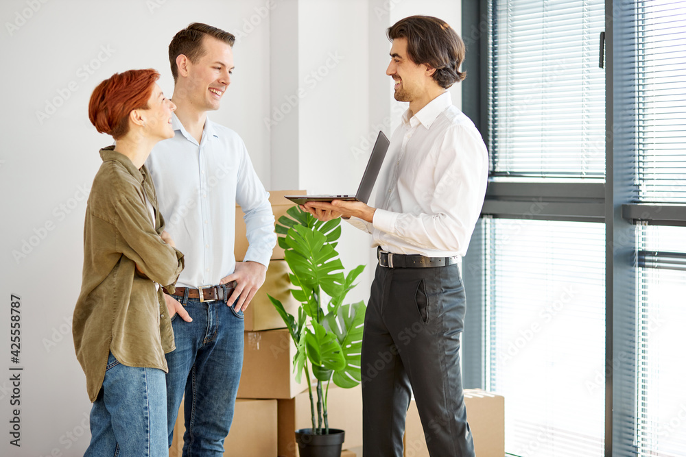 Real estate agent talking about terms of home purchase agreement showing it on laptop Real estate agent talking about terms of home purchase agreement showing it on laptop