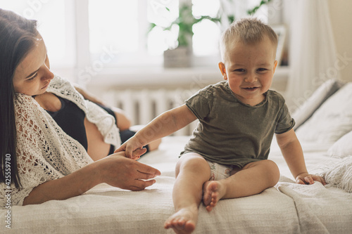 Young woman with her first child during second pregnancy. Motherhood and parenting concept. Toddler boy and mom. photo