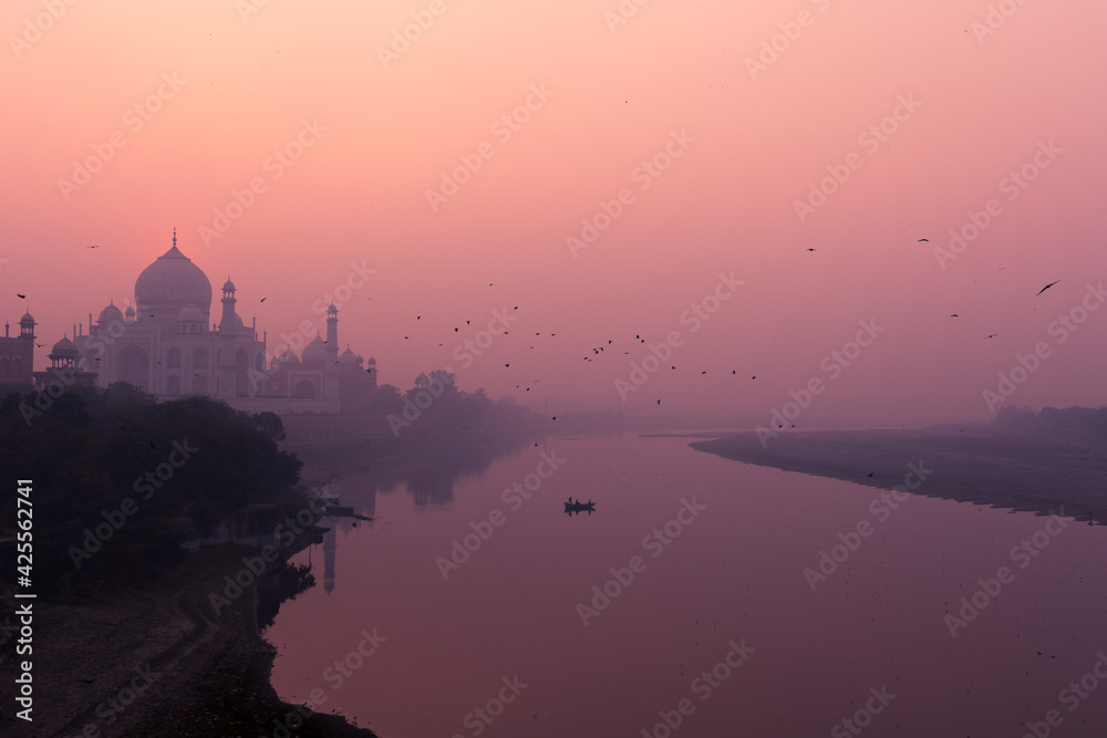Sun setting behind the Taj Mahal and over the river Yamuna