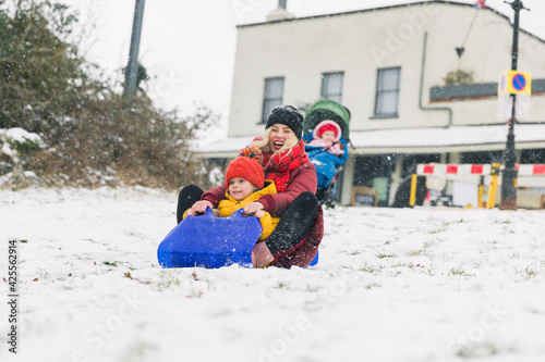 Young mother and son sledding. Winter fun. Vacation.
