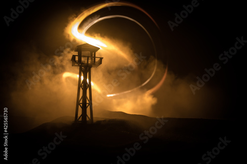 Creative artwork decoration. Silhouette of army watchtower at night. Selective focus