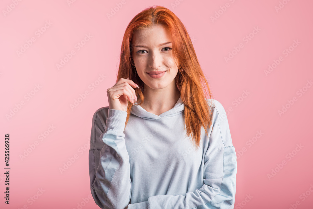 Beautiful young redhead girl in the studio on a pink background Beautiful young redhead girl in the studio on a pink background