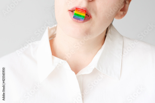 Man holds lgbt flag in his lips. Uncertainty man or woman.