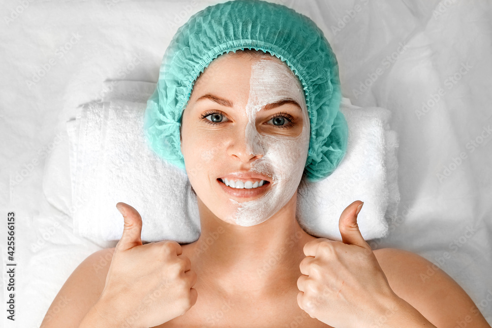 A beautician applies a mask to the face in a beauty salon. The concept of facial hygiene, cosmetic procedures, skin care, skin pore cleansing, hardware cosmetology. A beautician applies a mask to the face in a beauty salon. The concept of facial hygiene, cosmetic procedures, skin care, skin pore cleansing, hardware cosmetology.