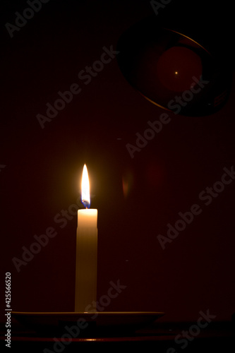 candle in the dark with electrical lamp