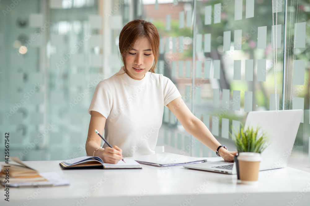 Asian Young Woman working on laptop. Freelancer at remote work. Female student learning on-line via computer. Blogger or journalist writing new article. Asian Young Woman working on laptop. Freelancer at remote work. Female student learning on-line via computer. Blogger or journalist writing new article.
