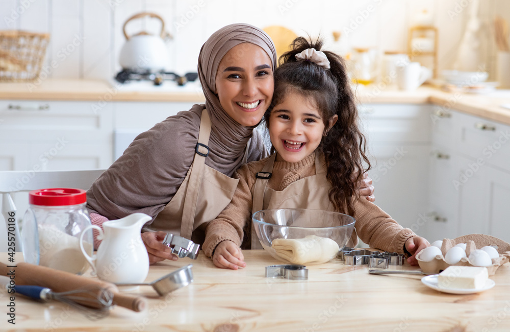 Happy Islamic Family Mother And Little Daughter Baking In Together In Kitchen Happy Islamic Family Mother And Little Daughter Baking In Together In Kitchen