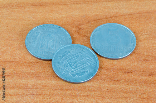 5 kopiyok coins of the Ukrainian hryvnia on wooden table. photo