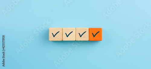 Checklist concept, Check mark on orange wooden blocks, blue background photo