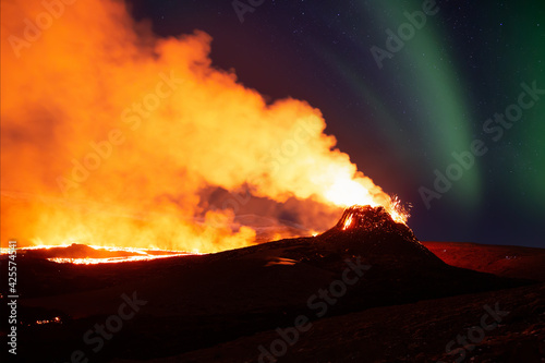 Murais de parede Aurora Borealis over erupting volcano in Geldingadal Iceland
